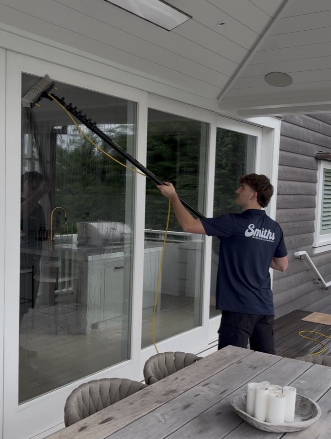 Technician using the PureWash water-fed pole system on an exterior window